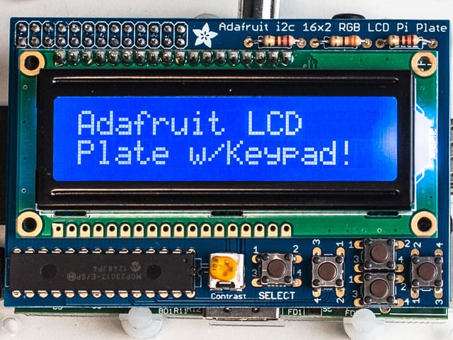 Top down view of a Adafruit Blue&White 16x2 LCD+Keypad Kit for Raspberry Pi. Display reads "Adafruit LCD Plate w/Keypad!"