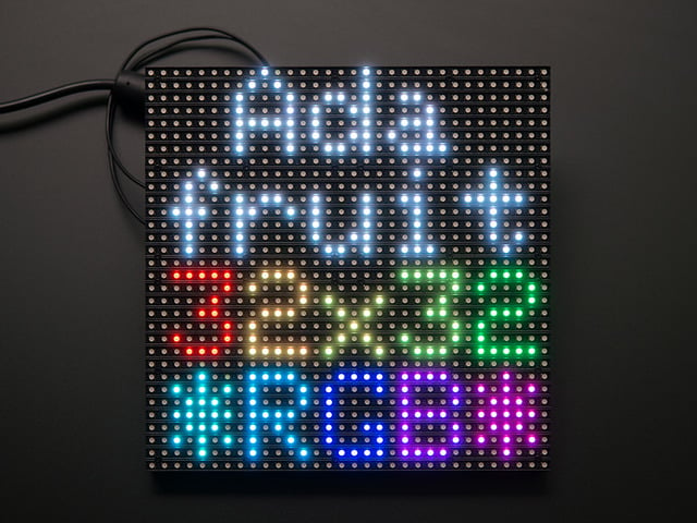 Assembled and powered on 32x32 RGB LED Matrix Panel - 6mm pitch. The matrix lights up "Adafruit 32x32 *RGB*"