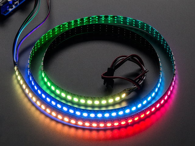 Adafruit NeoPixel Digital RGB LED Strip wired to a microcontroller, with all the LEDs in a rainbow