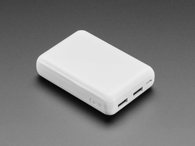 Angled shot of white rectangular USB battery pack with 4 dotted lights indicating battery is fully charged. 