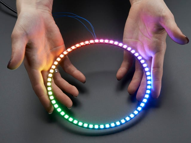 Hand holding NeoPixel Ring with 60   x 5050 RGB LED, lit up rainbow