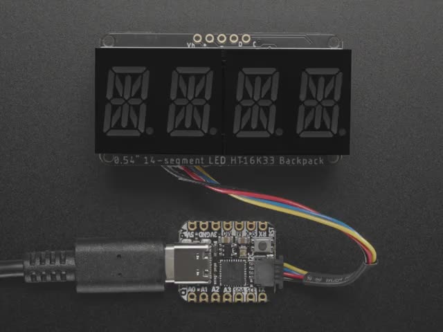 Overhead video of an assembled 14-segment LED backpack, emitting the follow text in blue LEDS: "AdaFruit 14-Segment Backpack"