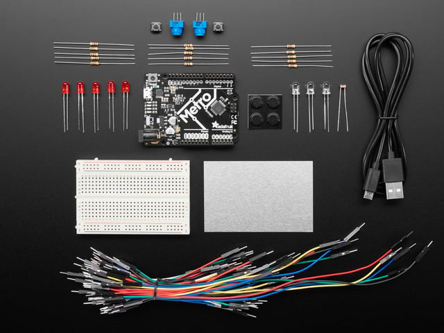 Budget pack kit contents, microcontroller board, breadboard, wires, and parts.