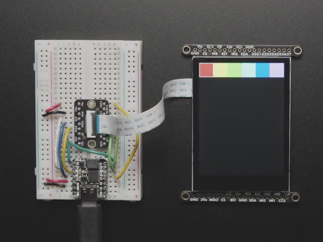 Overhead video of TFT breakout cabled to a QT Py on a breadboard. A red manicured finger draws a heart in red and purple.