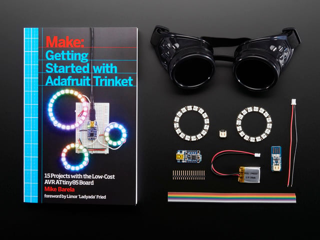 Getting Started with Adafruit Trinket book along with a collection of electronic parts included in kit.