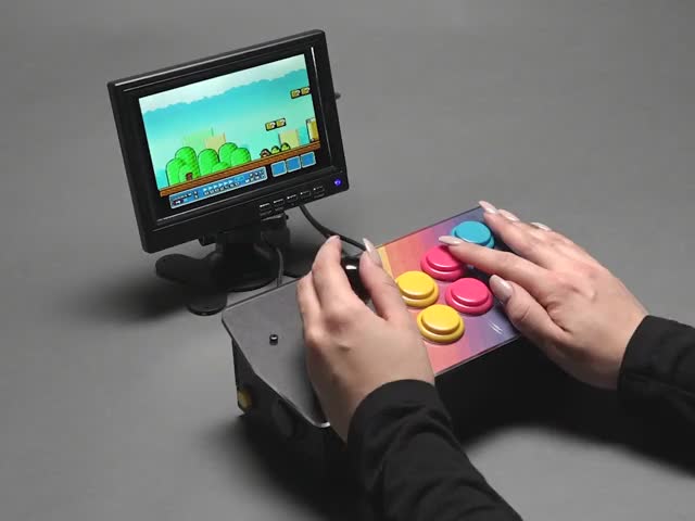 Angled video of two white hands playing Mario World on an assembled Pimoroni Picade Console Controller Kit connected to small monitor.