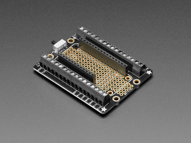 Angled shot of an Assembled Terminal Block Breakout FeatherWing for all Feathers with black headers. 