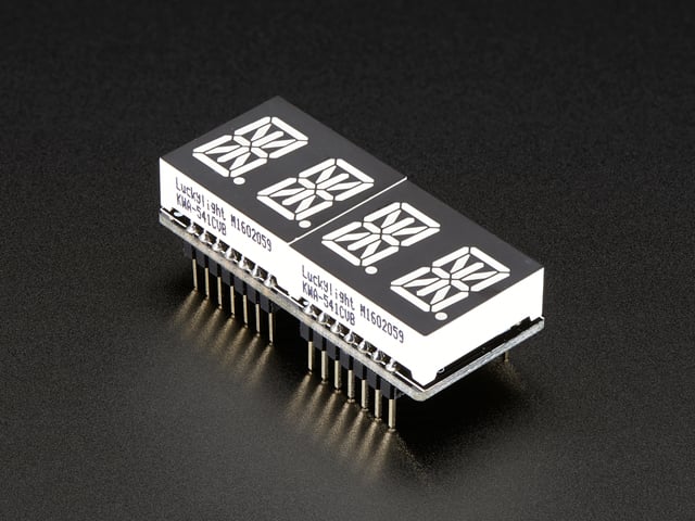 Angled shot of a rectangular shaped Quad Alphanumeric Display breakout board with an LED matrix soldered on.