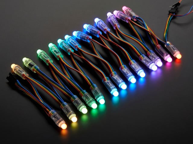 Array of many lit up LED pixel dots on wire strand, rainbow colored