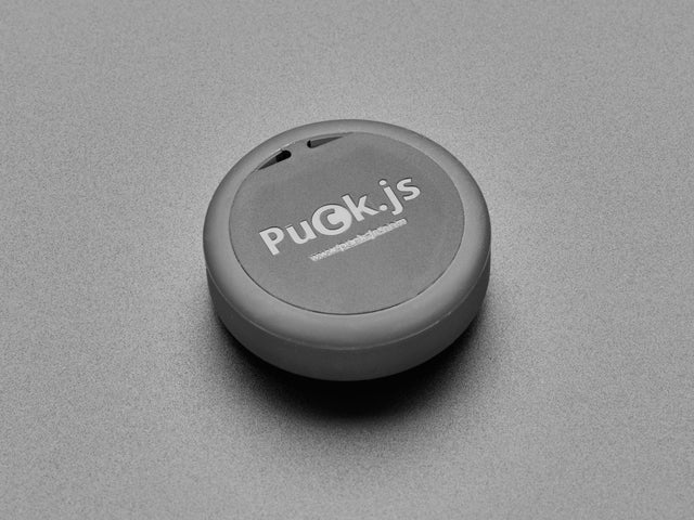 Angled shot of a Espruino Puck.js v2. 