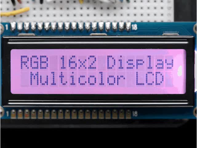 LCD wired on breadboard with backlight changing color with text displayed: "RGB 16x Display Mulitcolor LCD"