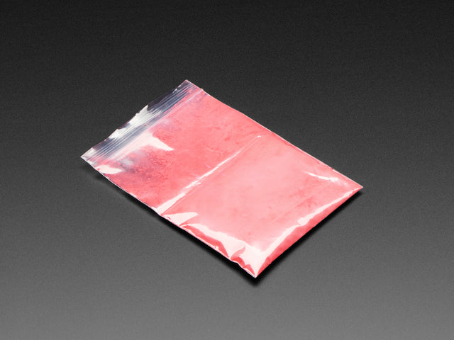 Angled shot of plastic baggy containing red thermochromic pigment powder. 