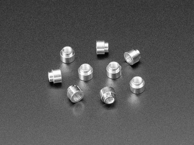 Angled shot of ten 3mm tall M3 standoff nuts.