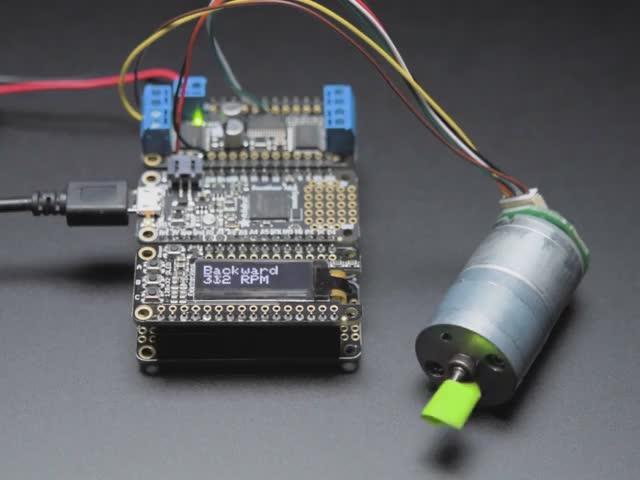 Angled view of a Geared DC Motor rotating while connected Circuitry shows RPM changing