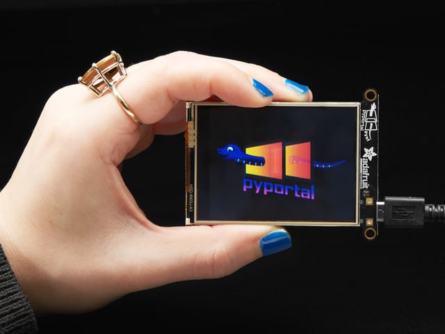 Hand holding PyPortal Titano development board with SAMD51, ESP32 Wifi, and 2.4" touchscreen TFT display.Adafruit PyPortal Pynt