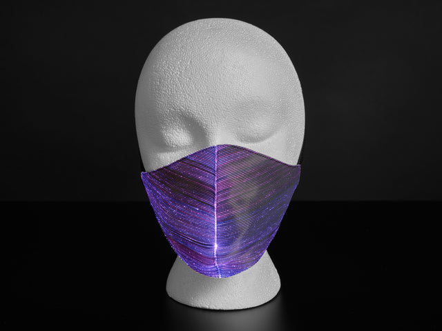 A styrofoam head wearing a black face mask with purple optic fibers.