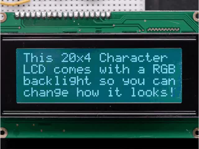 LCD wired on breadboard with backlight changing color with text displayed: "This 20x4 Character LCD comes with an RGB backlight so you can change how it looks".