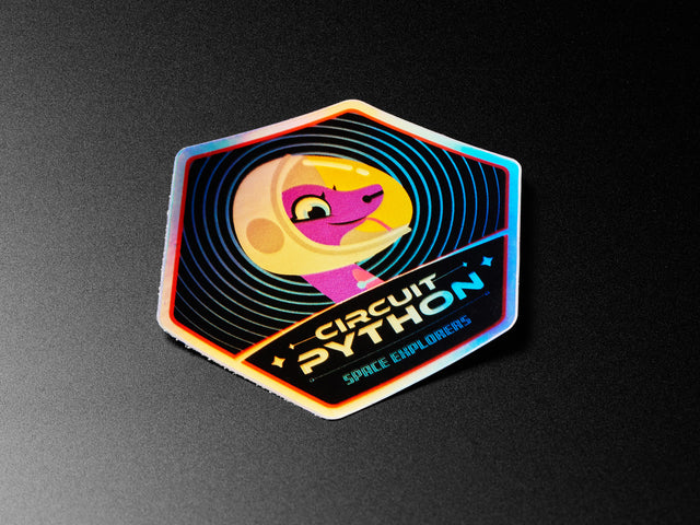 Holographic sticker with friendly snake wearing a space-helmet. Text says "Circuit Python Space Explorers"