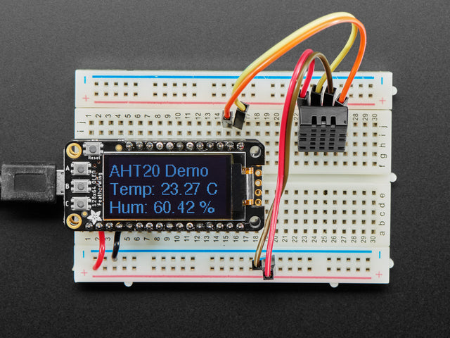 Top view of DHT20 sensor wired to a breadboard with an FeatherWing OLED display. The OLED shows the data from the temperature-humidity sensor.