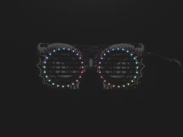 Top view of dragon eyeglass PCB. ADAFRUIT in rainbow LEDs scrolls across the mask.