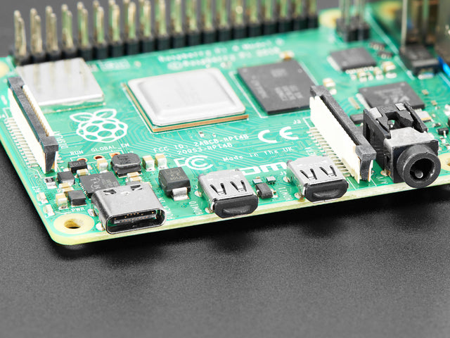 Close-up of a Raspberry Pi 4 with two black silicone dust covers protecting the micro HDMI ports.