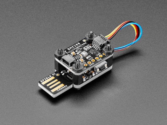 Angled shot of a USB key-shaped PCB with a sensor board stacked on top via black nylon screws.