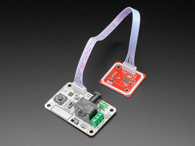 Angled shot of a white board connected to a red board via ribbon cable.