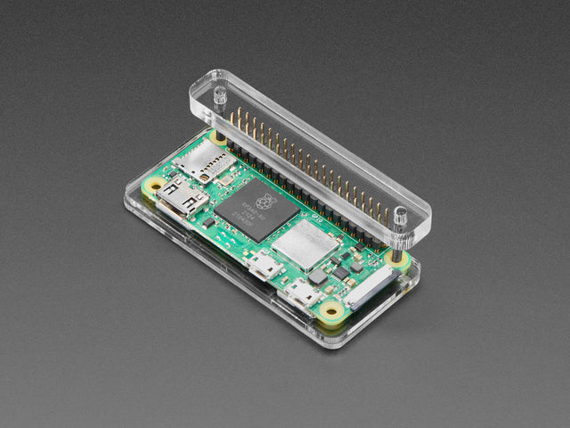 Angled shot of a green rectangular microcontroller, a Raspberry Pi Zero, assembled into a plastic and acrylic header installation jig.