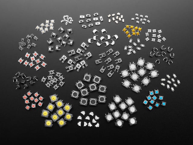 Overhead shot of dozens of different sized and colored packs of tactile switches.