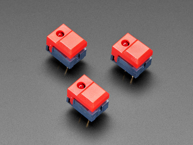 Angled shot of three red plastic step-switches with red LEDs.