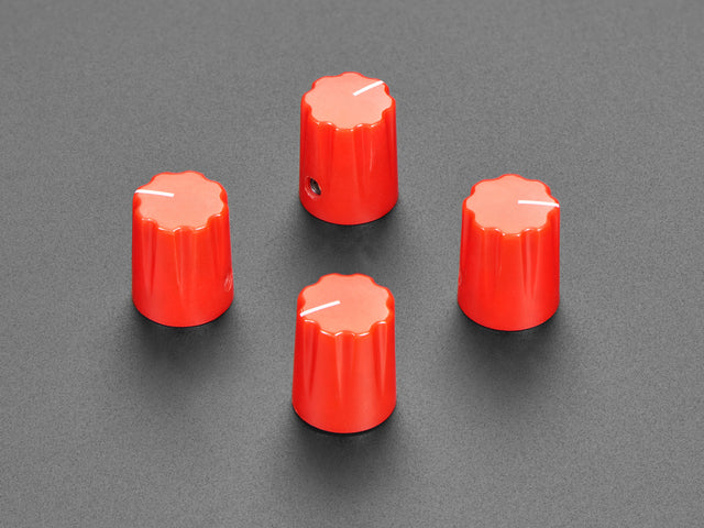 Angled shot of four red micro potentiometer knobs.