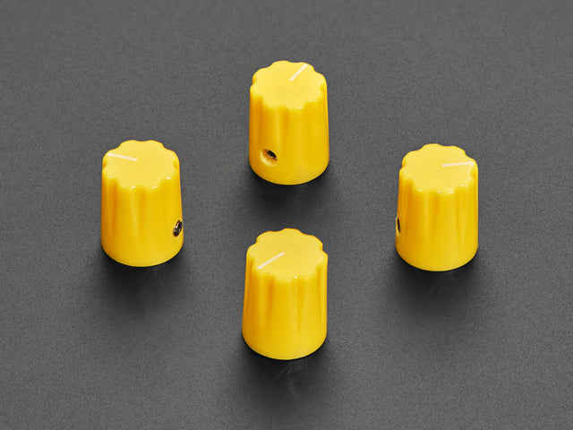 Angled shot of four yellow micro knobs.