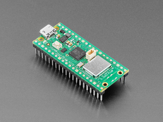 Angled shot of green rectangular microcontroller with a Wi-Fi module and pre-soldered headers.