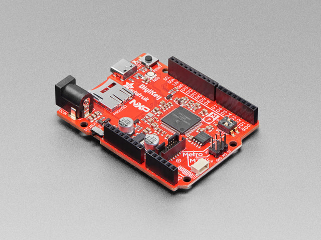 Angled shot of red credit-card sized microcontroller.