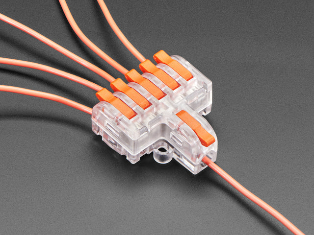 Angled shot of clear 1-to-6 Wiring Block Connector assembled with red wires.