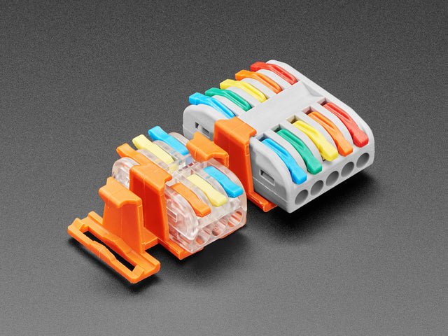 Angled shot of two orange plastic buckles assembled with two different wiring block connectors.