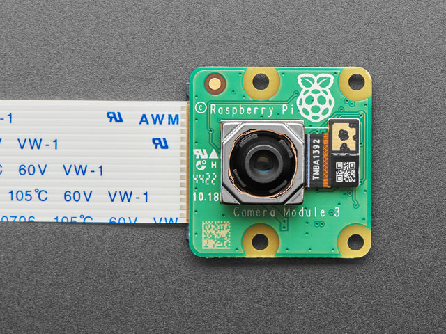 Overhead shot of green, square camera module with cable.