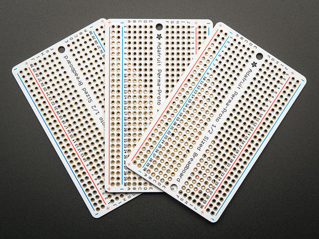 Top view of three fanned out Adafruit Perma-Proto Half-sized Breadboard PCBs.