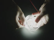 Video of a hand stretching a double-sided LED strip with cool white LEDs like an accordion.