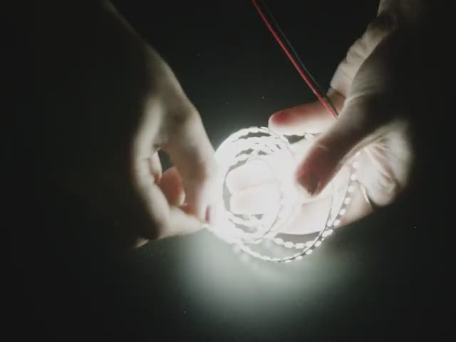 Video of a hand stretching a double-sided LED strip with cool white LEDs like an accordion.