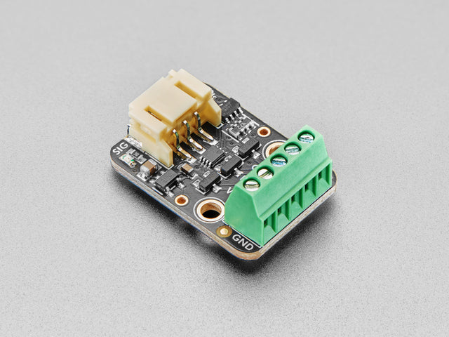 Angled shot of rectangular RGB LED driver board with green terminal blocks.