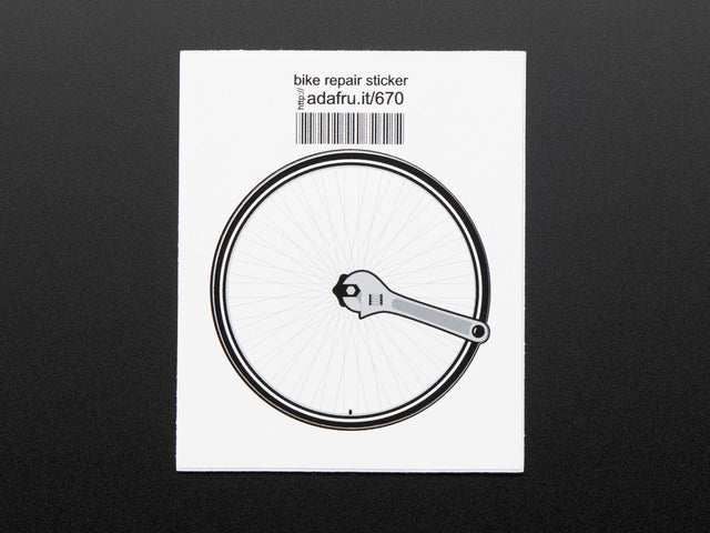 Circular sticker of a bicycle wheel in black and grey with a wrench turning the central nut, over a white background. Mounted on white paper with barcode. 
