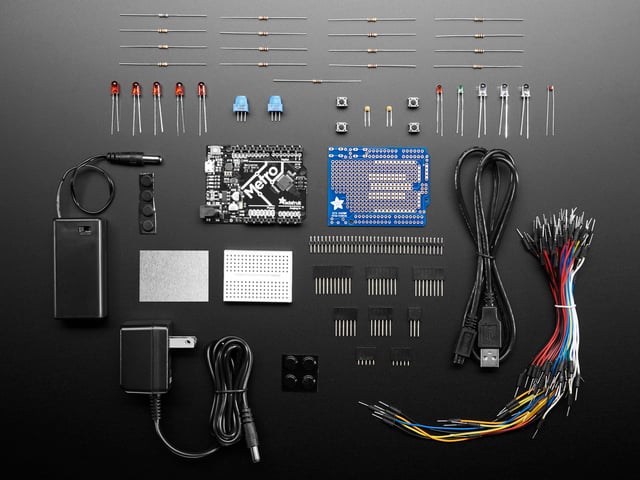 Adafruit Metro 328 Starter Pack showing kit contents, with boards, PCBs, wires and power supplies